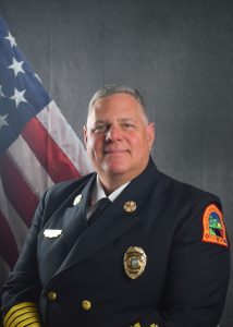 Portrait of David Cambareri in Class A uniform in front of American flag backdrop